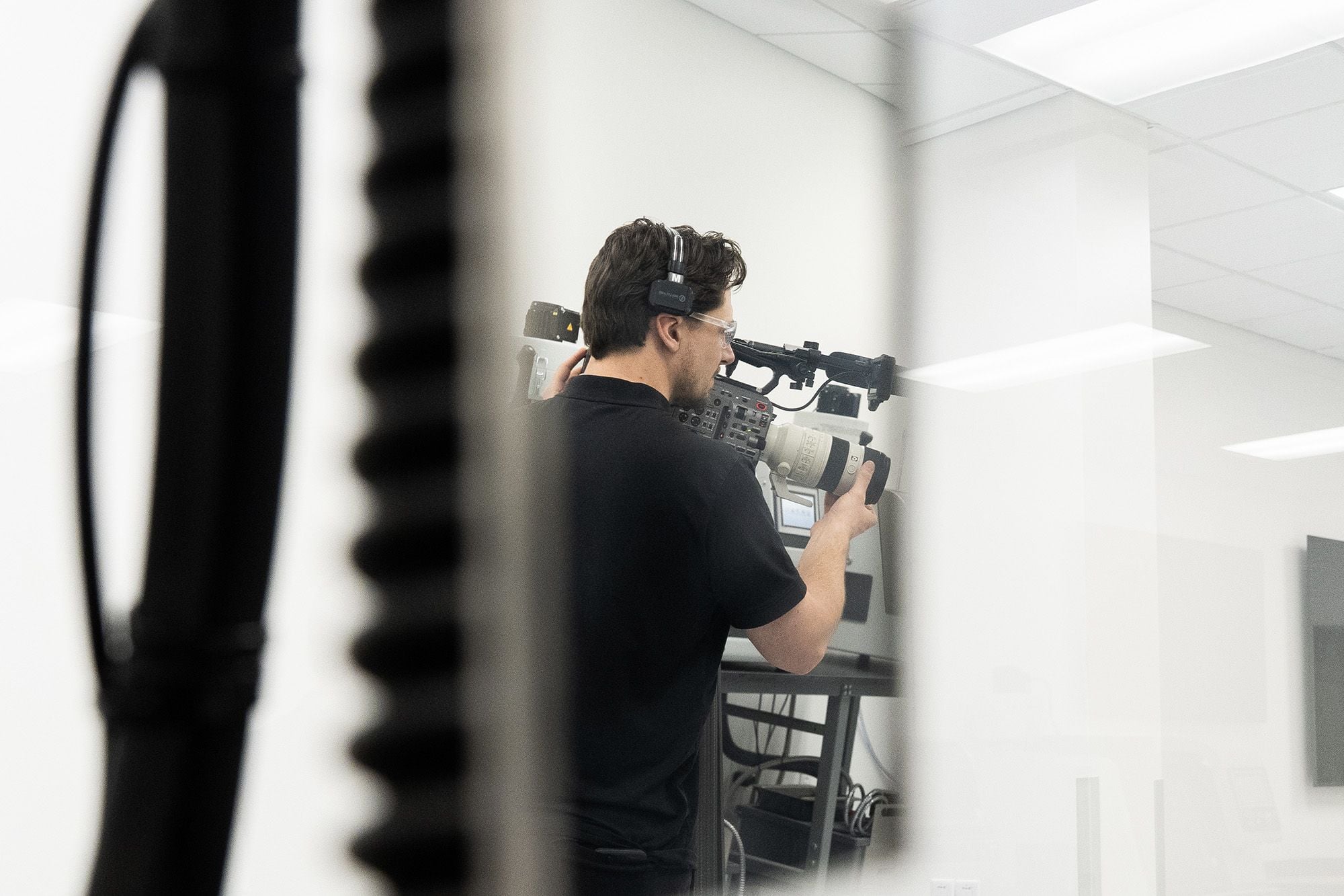 Technician inspecting a machined part under a microscope in a quality lab